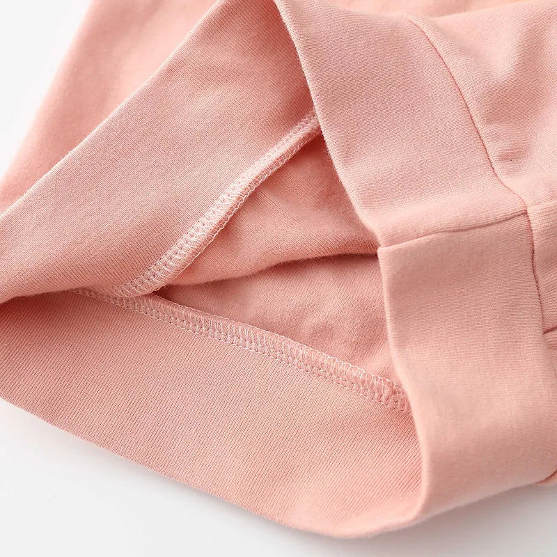 Close-up of Girls Pom Pom Jumper fabric detail in soft pink color, showing inner seam and high-quality stitching.