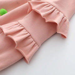 Close-up of pink Girls Pom Pom Jumper with ruffled sleeves for ages 2-10 years from Bijou Bubs.